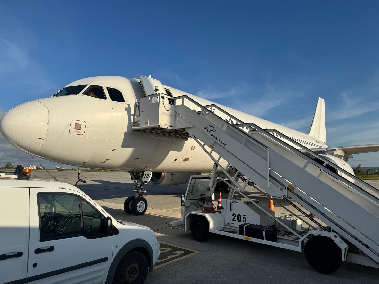 Airbus A320 on stand with steps and ground equipment in attendance